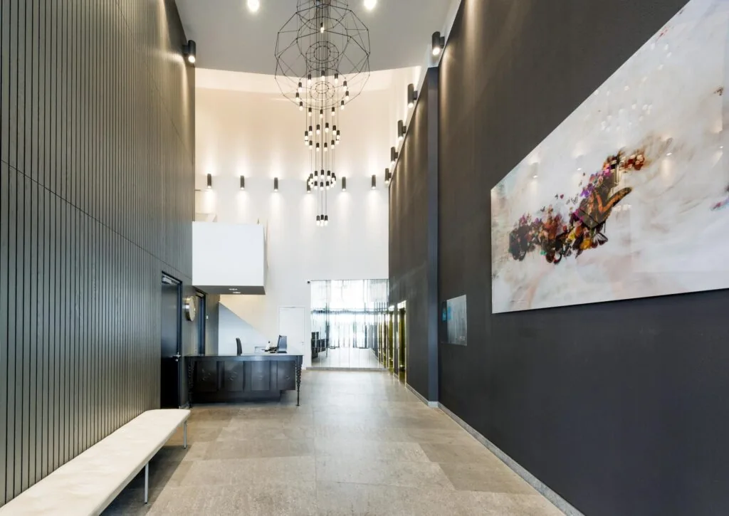 Moderne ontvangsthal aan de Grote Marktstraat met hoge plafonds, strakke inrichting en kunst aan de muur.